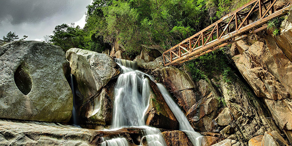 bridge over rive with waterfall in the background